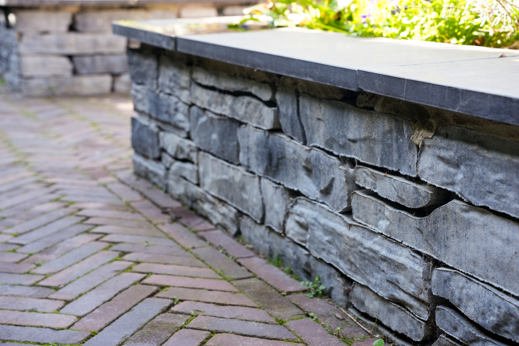 Speels muurtje bij plantenbak aangelegd door Hoogendijk Bestratingen